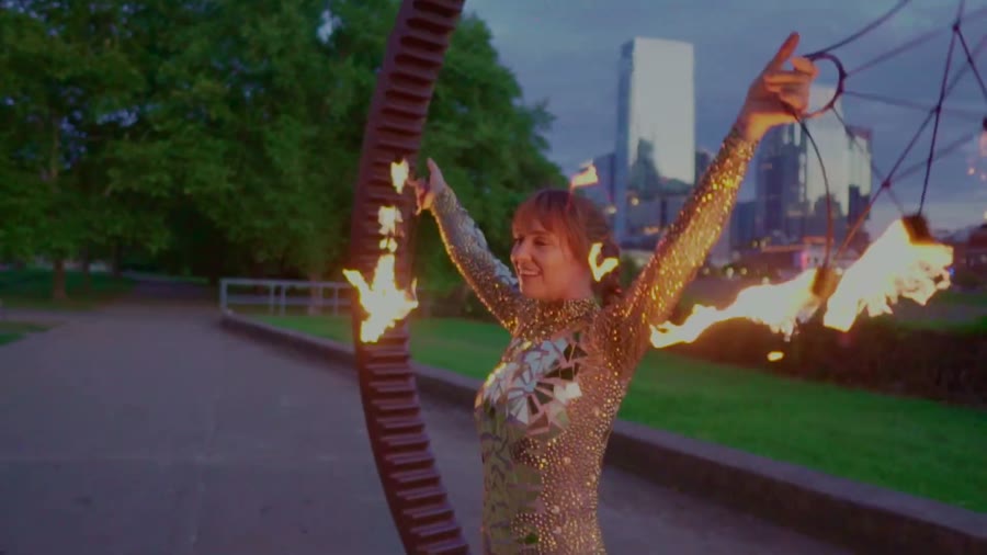 Sarah Grace performing fire fans with Nashville skyline in the background